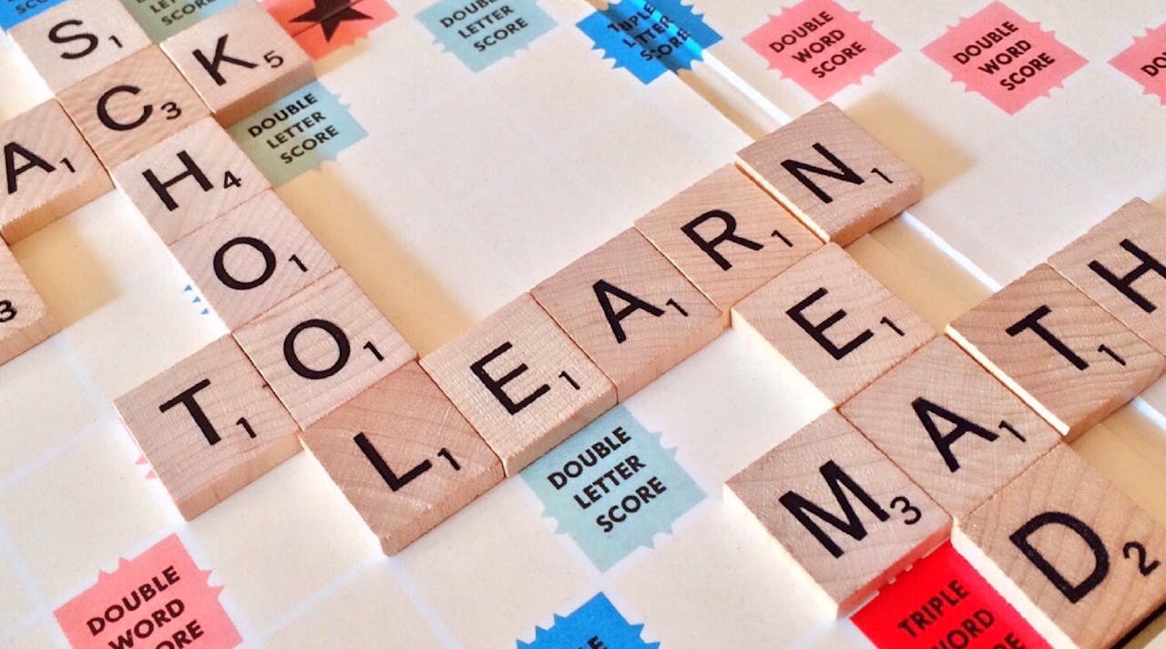 About Close-up of Scrabble tiles forming words related to education and school.